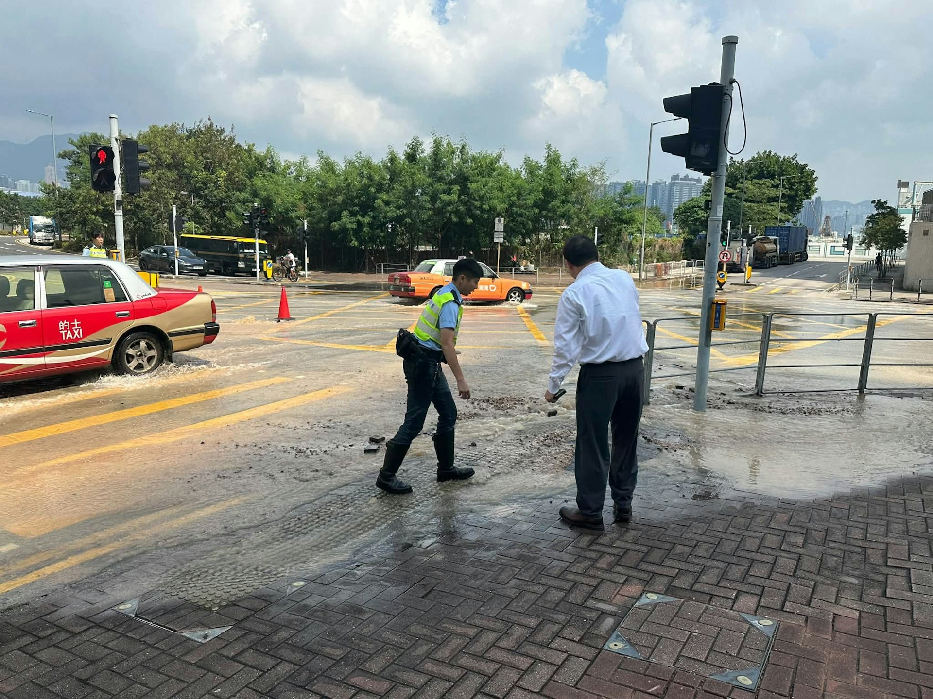 红磡道与庇利街交界处水管爆裂致路面塌陷,巴士后轮受困多条线路改道 红磡道与庇利街交界处水管爆裂致路面塌陷,巴士后轮受困多条线路改道