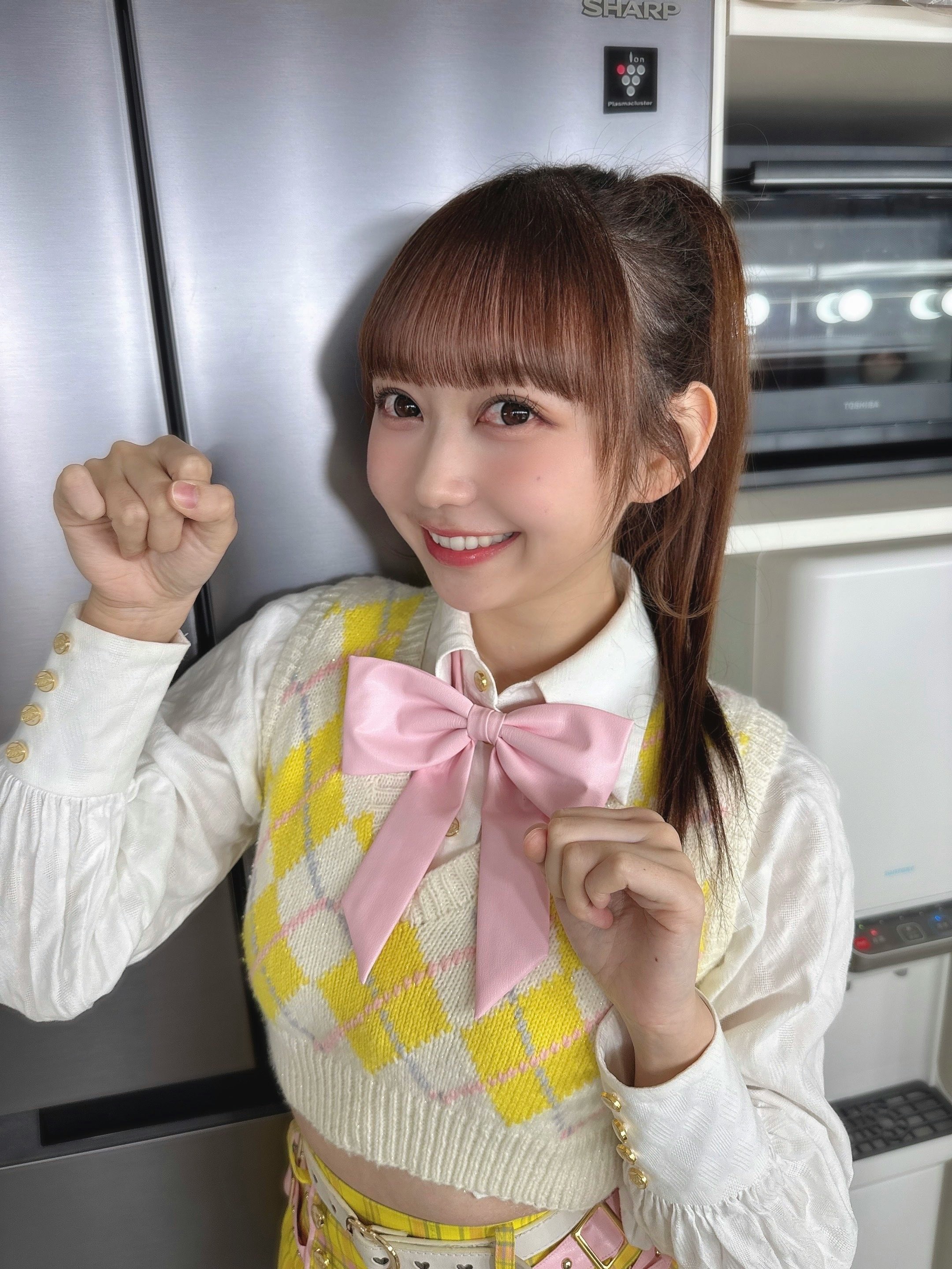 大盛真步穿着黄色格纹服装和粉色蝴蝶结