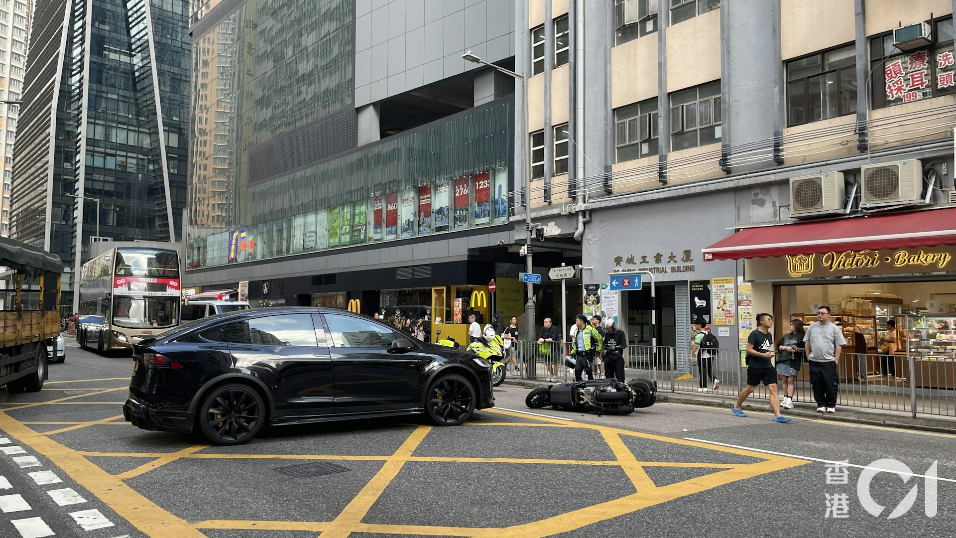 涉事黑色私家车停在路口,电单车则侧翻跌在私家车前方的行车线中央。
