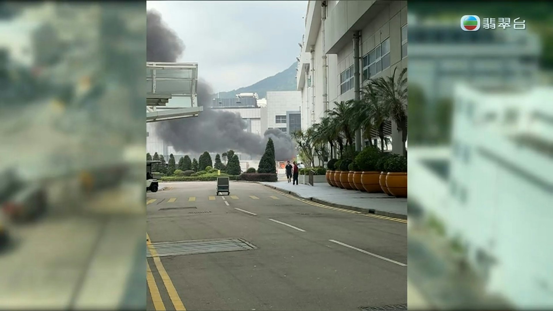 浓浓黑烟不断向上升,几乎遮挡了部分电视城建筑物的外墙。(电视截图)
