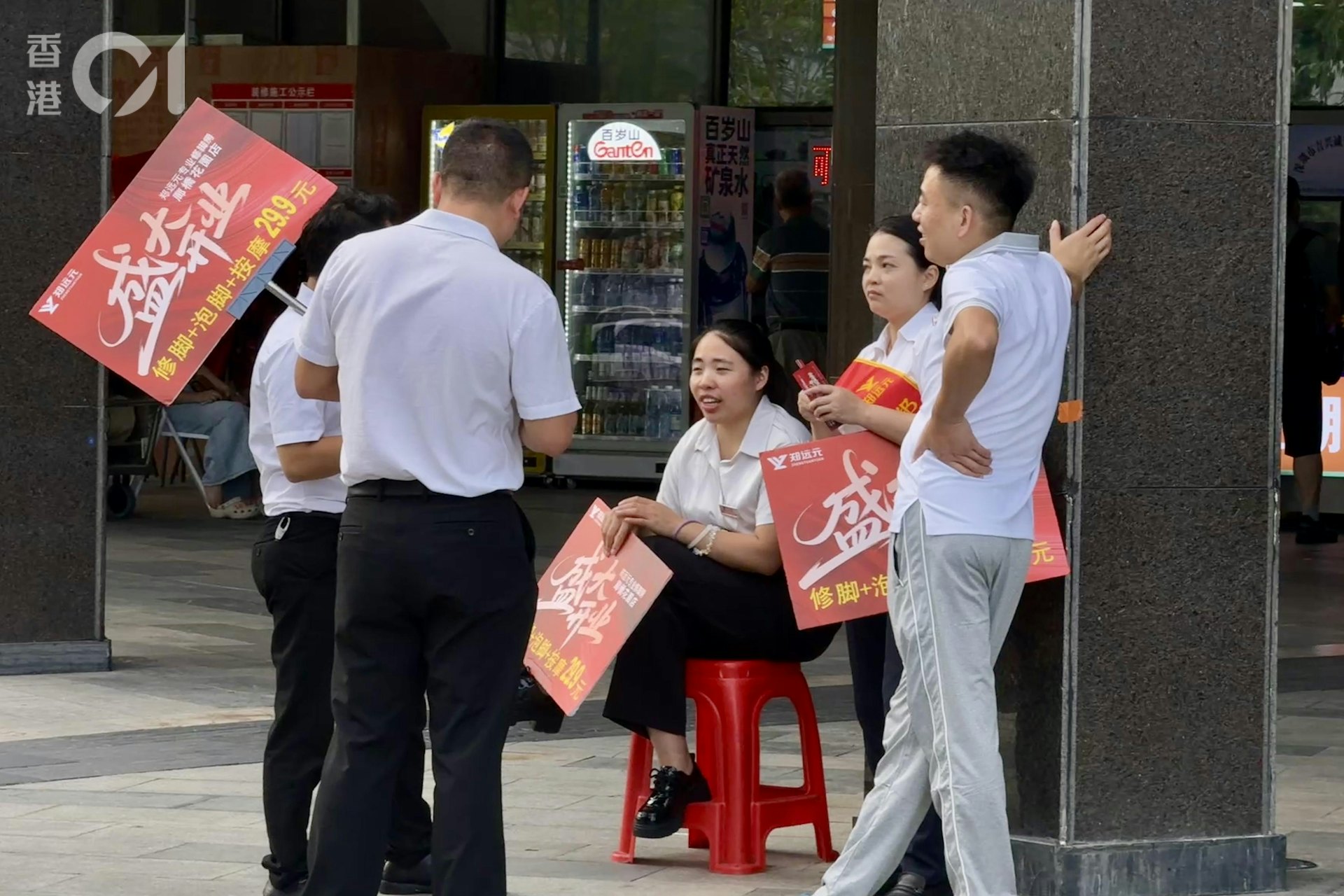 按摩店员工在街上招客,冷清的小区开始变得热闹。