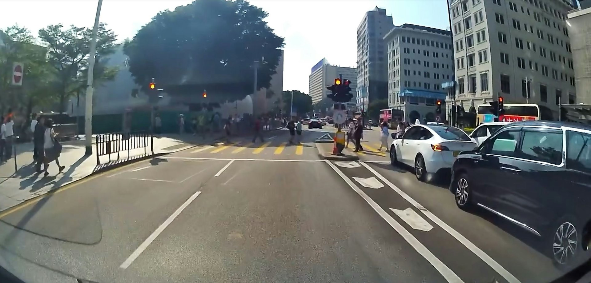 多名途人正在沿行人过路处按照灯号过马路,见状立即停步让车,保时捷直冲过去,幸没有撞到途人。(Facebook群组「车cam L(香港群组)」影片截图)