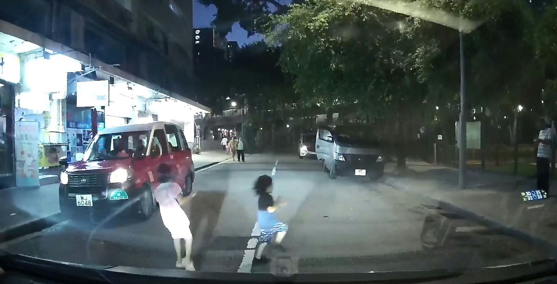 司机随即由慢驶紧急煞掣,幸及时煞车,没有撞到他们,女童跑回左行人路,男童则索性继续冲去对面右边行人路。(Facebook群组「车cam L(香港群组)」影片截图)