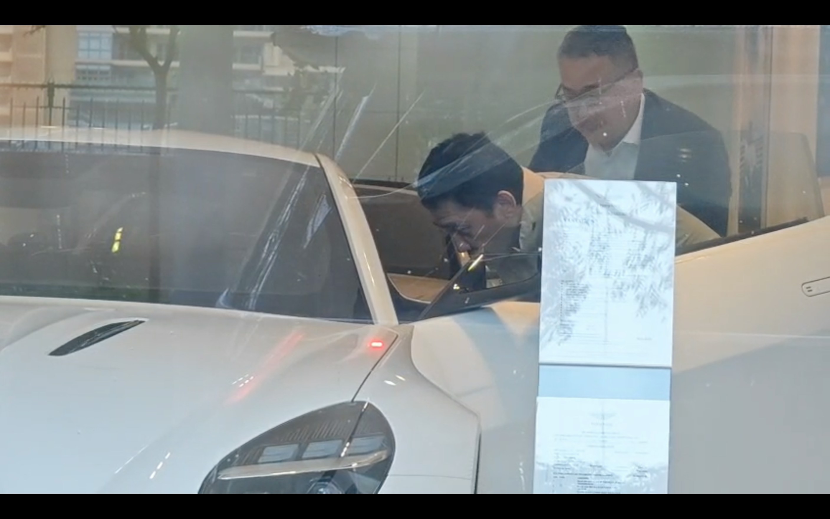 展示場の車内を近くで確かめるトニー・レオン