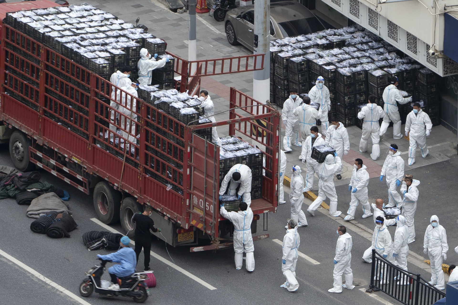 上海身穿 PPE 的工人從卡車上卸下雜貨,然後將它們分發給當地居民。(Chinatopix Via AP) 上海身穿 PPE 的工人從卡車上卸下雜貨,然後將它們分發給當地居民。(Chinatopix Via AP)